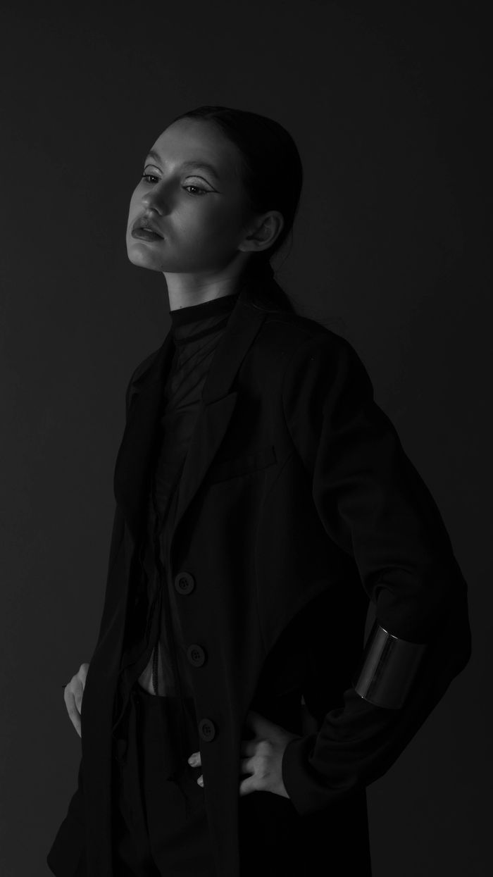 Captivating black and white portrait of a woman in elegant attire, exuding style and grace.