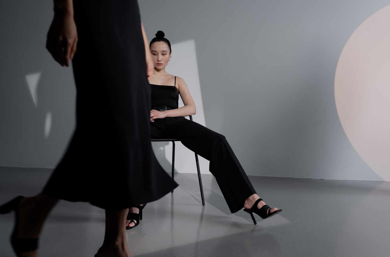 Chic and modern fashion photoshoot featuring a woman in black in a stylish studio setup.