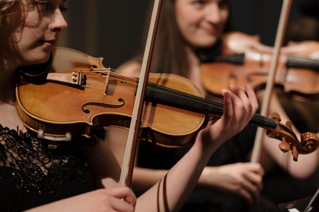 Musicians performing classical music with violins, showcasing skill and concentration.